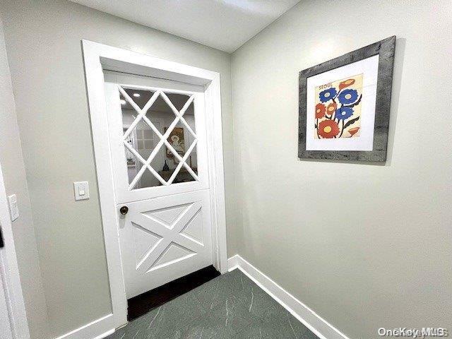2906 Oceanside Rd, Oceanside, NY 11572 - entryway featuring baseboards and dark marble finish flooring