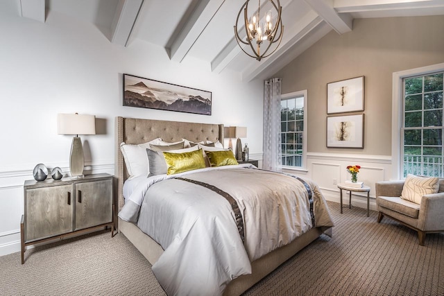 carpeted bedroom with a chandelier, a wainscoted wall, and a decorative wall