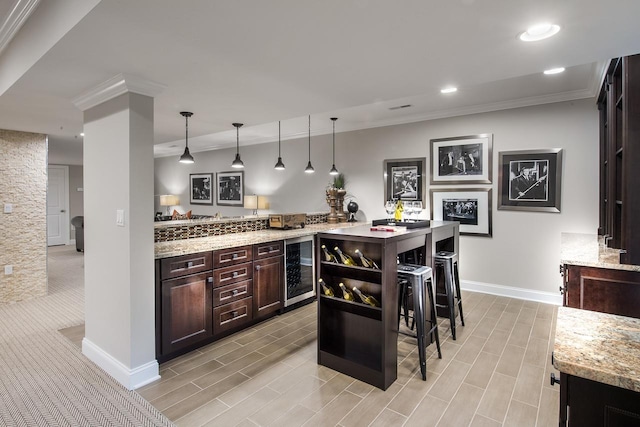 bar featuring crown molding, beverage cooler, baseboards, recessed lighting, and hanging light fixtures