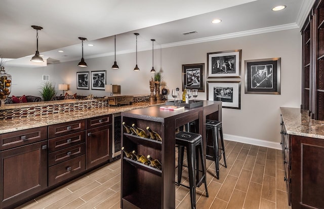 bar area with crown molding, wood tiled floors, baseboards, pendant lighting, and recessed lighting