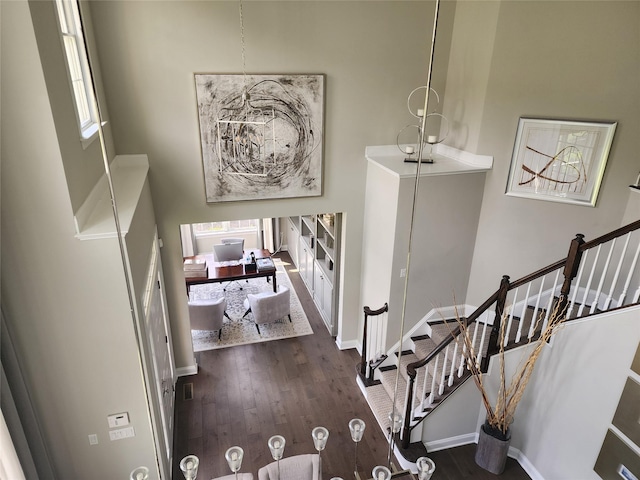 entrance foyer featuring wood finished floors, stairs, and baseboards