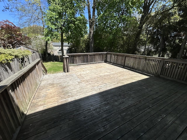 wooden terrace with a fenced backyard
