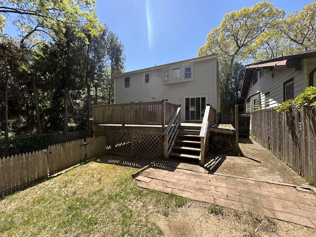 rear view of house featuring fence private yard and a wooden deck