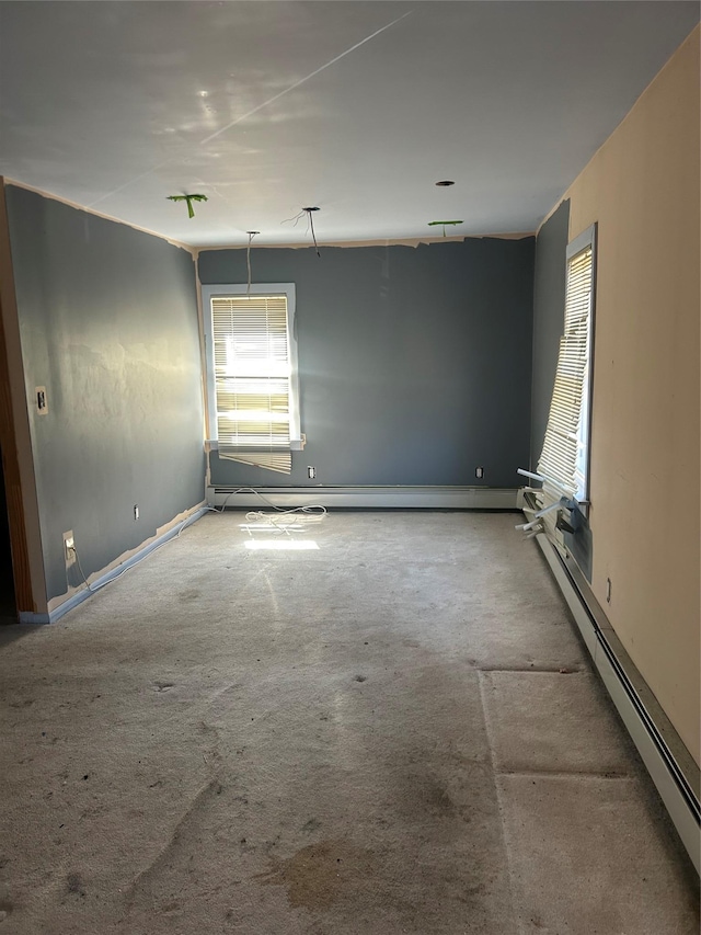 carpeted empty room with baseboards and a baseboard heating unit