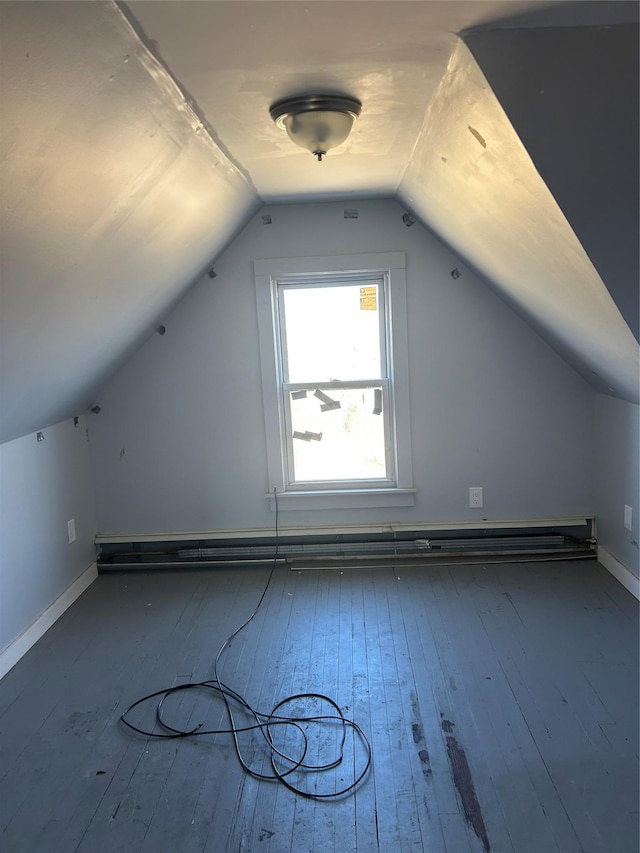 additional living space with a baseboard radiator, lofted ceiling, wood-type flooring, and baseboards
