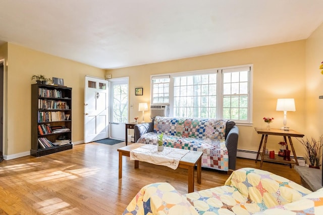 living area with cooling unit, wood finished floors, and baseboards