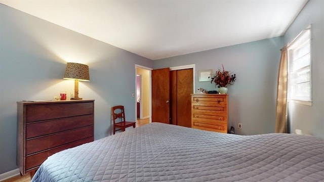 bedroom featuring baseboards and a closet