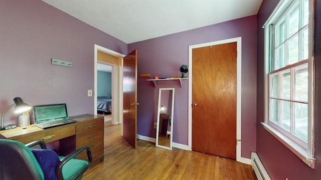 office space featuring light wood-type flooring, baseboards, and a baseboard radiator