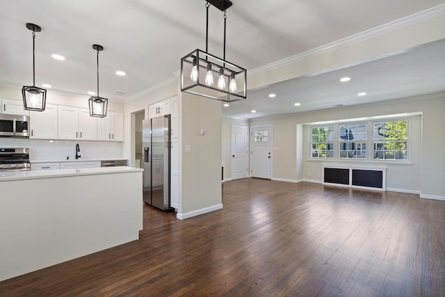 kitchen with crown molding, light countertops, and appliances with stainless steel finishes