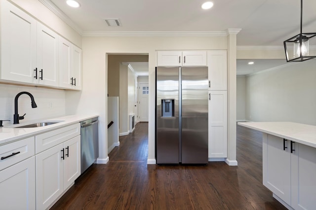 kitchen with a sink, ornamental molding, dark wood-type flooring, visible vents, and appliances with stainless steel finishes