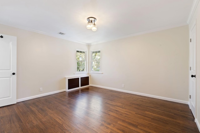 empty room with baseboards, ornamental molding, visible vents, and wood finished floors