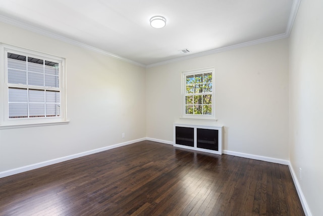 empty room featuring baseboards, hardwood / wood-style floors, and crown molding