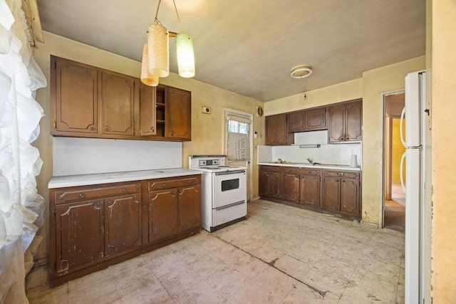 kitchen featuring a sink, white appliances, open shelves, pendant lighting, and light countertops