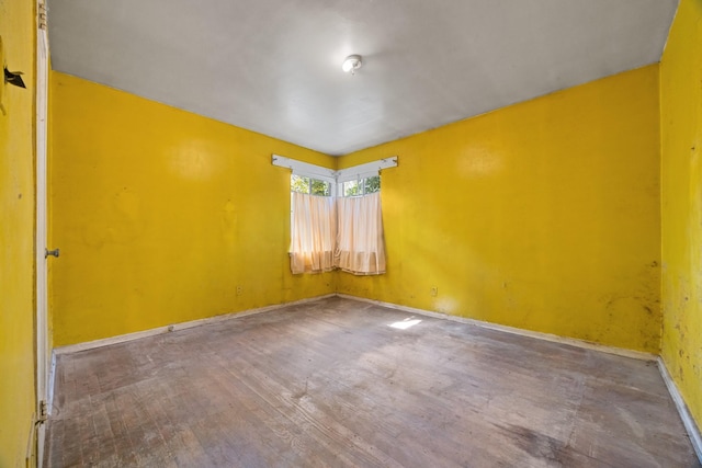 empty room with baseboards and wood finished floors