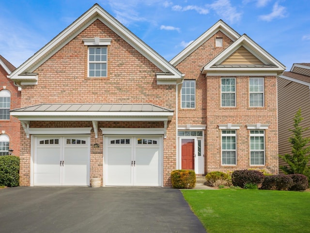 417 Vassar Pl, Fishkill, NY 12524 - view of front facade with a standing seam roof, metal roof, aphalt driveway, a front lawn, and an attached garage