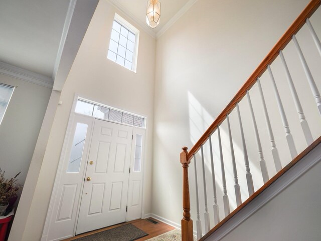 417 Vassar Pl, Fishkill, NY 12524 - entryway featuring baseboards, wood finished floors, a towering ceiling, ornamental molding, and stairway