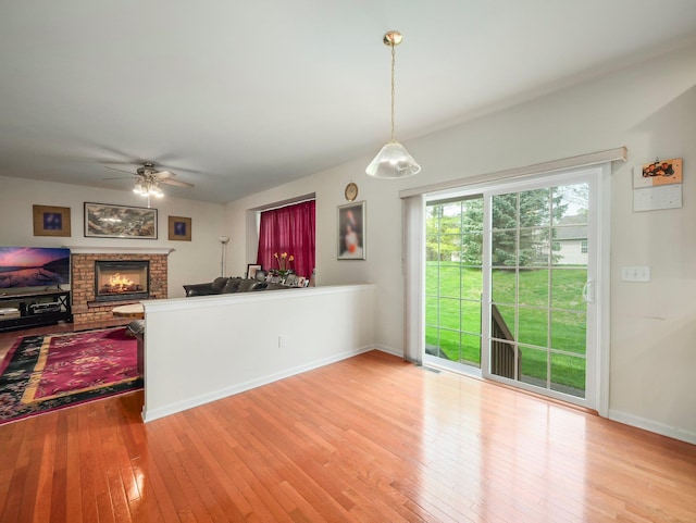 417 Vassar Pl, Fishkill, NY 12524 - kitchen featuring a fireplace, a ceiling fan, baseboards, decorative light fixtures, and light wood-type flooring