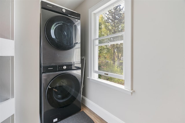 67 Arnett Rd, Rhinebeck, NY 12572 - laundry area featuring stacked washer / drying machine, wood finished floors, and baseboards