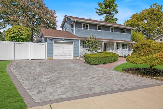 66 Rockland Dr, Jericho, NY 11753 - view of front of house with an attached garage, decorative driveway, a porch, and stone siding
