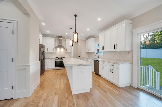 kitchen with white cabinetry, appliances with stainless steel finishes, a kitchen island, and a sink