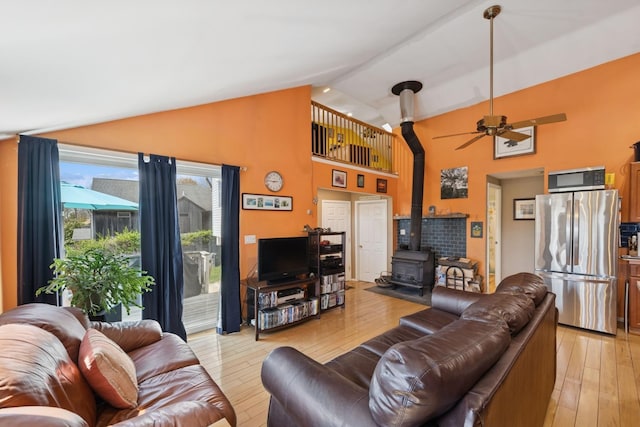 143 Tuthill Rd, Montauk, NY 11954 - living area with a wood stove, light wood finished floors, ceiling fan, and high vaulted ceiling