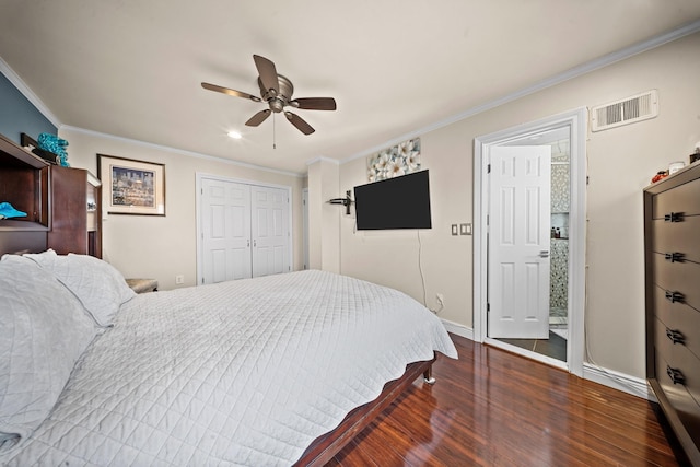 bedroom featuring dark wood-style floors, ornamental molding, baseboards, a ceiling fan, and a closet