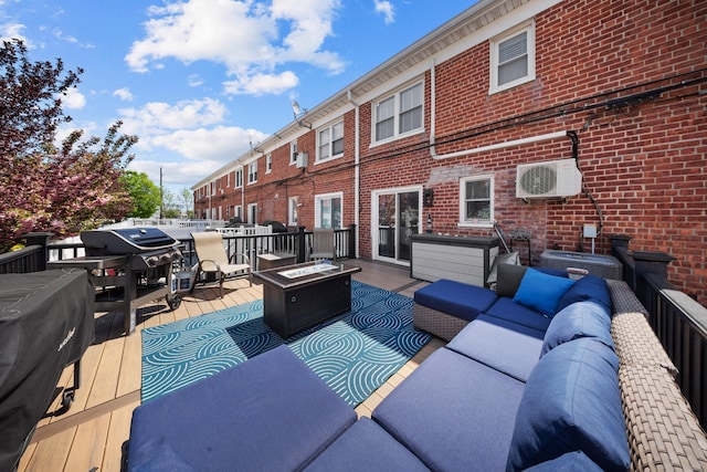 wooden deck featuring an outdoor living space with a fire pit and a cooling unit