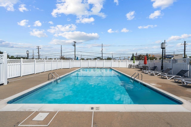 community pool featuring fence and a patio area