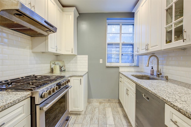 34-06 81st Unit 42, Jackson Heights, NY 11372 - kitchen featuring a sink, under cabinet range hood, light wood finished floors, white cabinetry, and appliances with stainless steel finishes