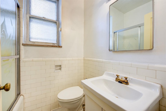 34-06 81st Unit 42, Jackson Heights, NY 11372 - full bath with a sink, tile walls, toilet, a wainscoted wall, and bath / shower combo with glass door