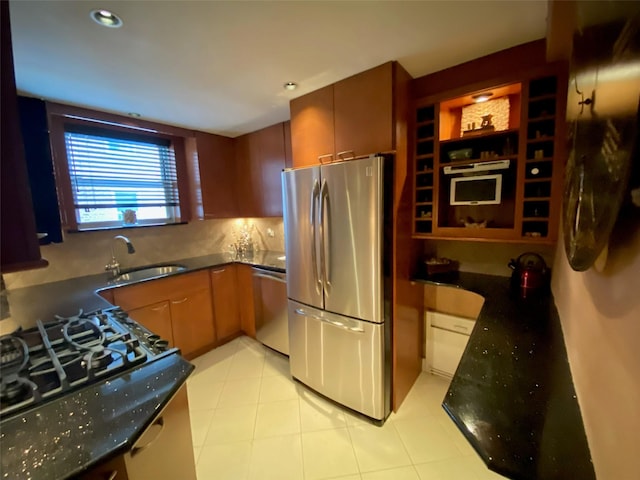 kitchen with a sink, dark stone counters, stainless steel appliances, decorative backsplash, and recessed lighting