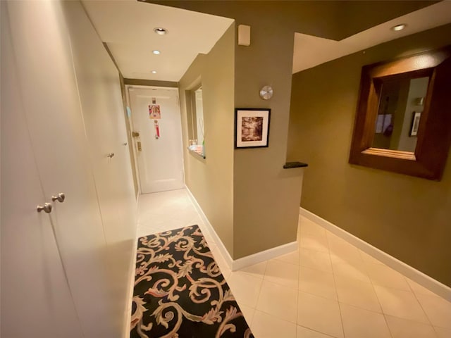 corridor with baseboards, tile patterned flooring, and recessed lighting
