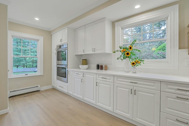 490 Bellwood Ave, Sleepy Hollow, NY 10591 - kitchen with baseboard heating, stainless steel double oven, light wood-type flooring, light countertops, and recessed lighting