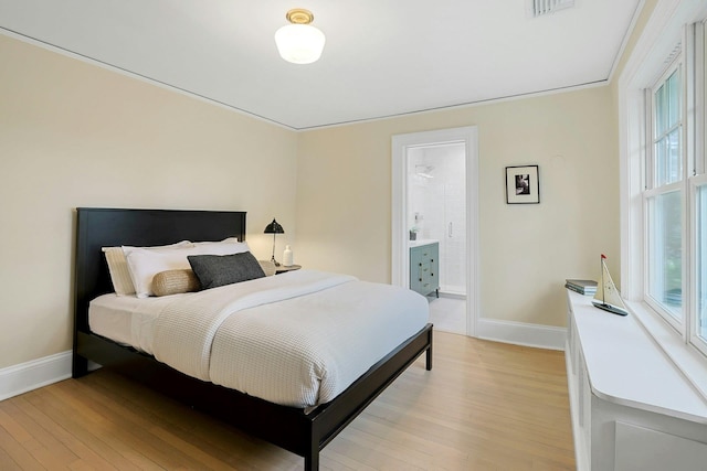 490 Bellwood Ave, Sleepy Hollow, NY 10591 - bedroom with baseboards, light wood-style floors, and connected bathroom