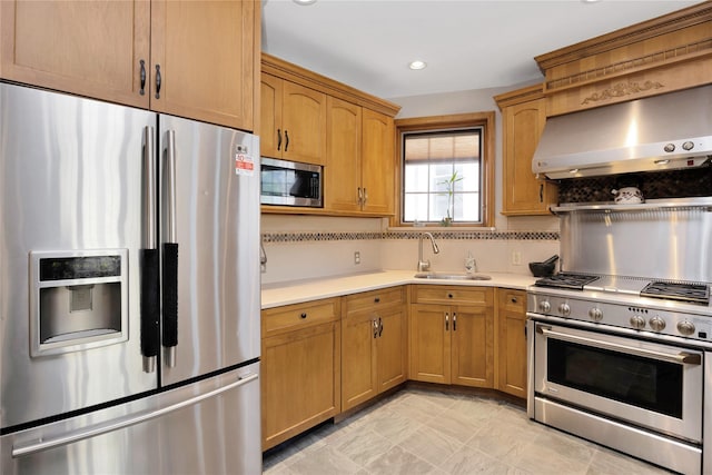 kitchen featuring stainless steel appliances, a sink, decorative backsplash, wall chimney range hood, and light countertops