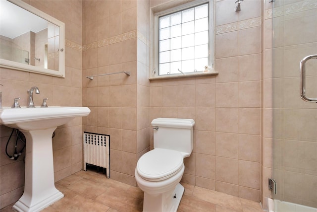 full bathroom with toilet, a stall shower, radiator, tile walls, and tile patterned flooring
