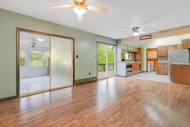 59 Longdale Rd, Mahopac, NY 10541 - unfurnished living room with a baseboard heating unit, washer / dryer, light wood-type flooring, ceiling fan, and plenty of natural light