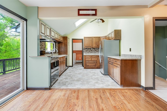 59 Longdale Rd, Mahopac, NY 10541 - kitchen with freestanding refrigerator, brown cabinets, decorative backsplash, light wood-style floors, and a skylight