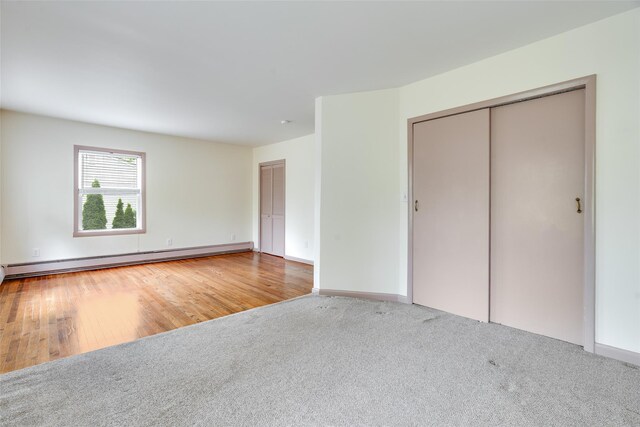 59 Longdale Rd, Mahopac, NY 10541 - unfurnished bedroom with baseboard heating, carpet, baseboards, a closet, and wood finished floors