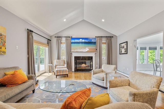 living area with a baseboard heating unit, vaulted ceiling, wood finished floors, plenty of natural light, and recessed lighting