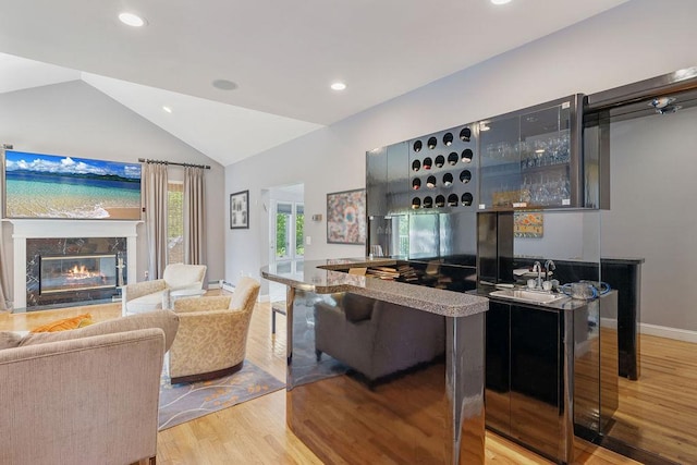 indoor bar with wood finished floors, recessed lighting, lofted ceiling, a fireplace, and baseboards