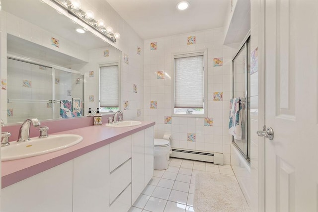 full bathroom featuring baseboard heating, tile patterned flooring, double vanity, toilet, and shower / bath combination with glass door