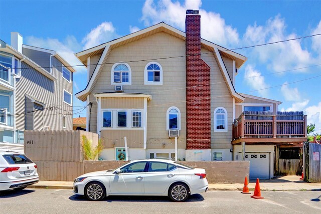 view of front of property featuring an attached garage, a chimney, and cooling unit