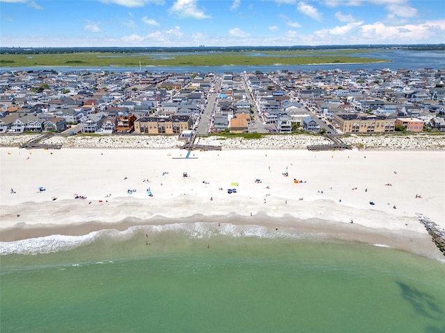 drone / aerial view with a view of the beach, a water view, and a residential view