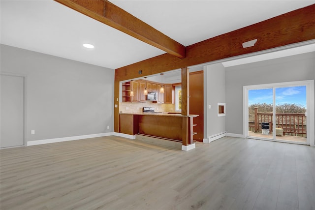unfurnished living room with plenty of natural light, baseboards, and light wood-type flooring