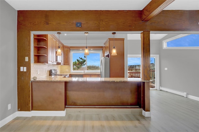 kitchen with freestanding refrigerator, baseboard heating, light stone countertops, stove, and backsplash