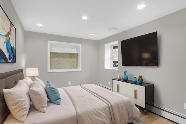 bedroom with a baseboard radiator, light wood finished floors, and recessed lighting