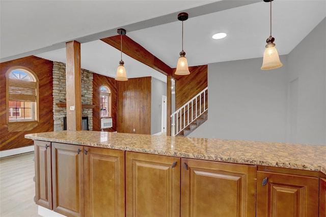 kitchen with wood walls, beam ceiling, light stone counters, and a fireplace