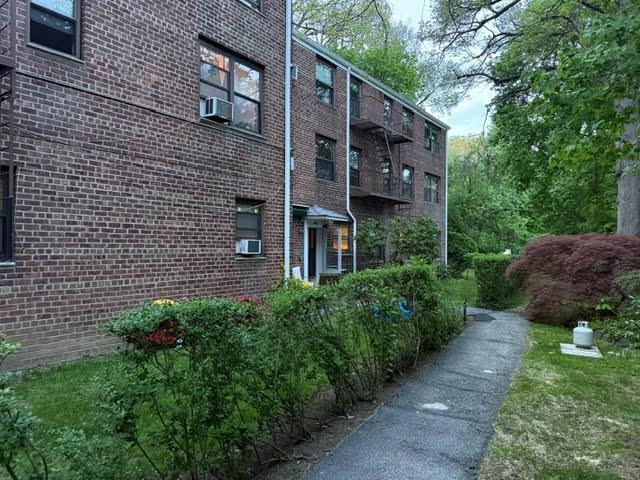view of side of home with cooling unit and brick siding