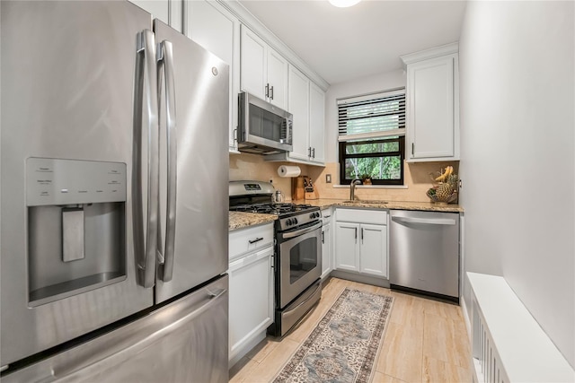 52 Rockledge Rd Unit 2A, Hartsdale, NY 10530 - kitchen with appliances with stainless steel finishes, white cabinetry, light stone counters, and a sink